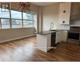 A kitchen with a large island and wooden floors.