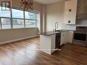 A kitchen with a large island and wooden floors.