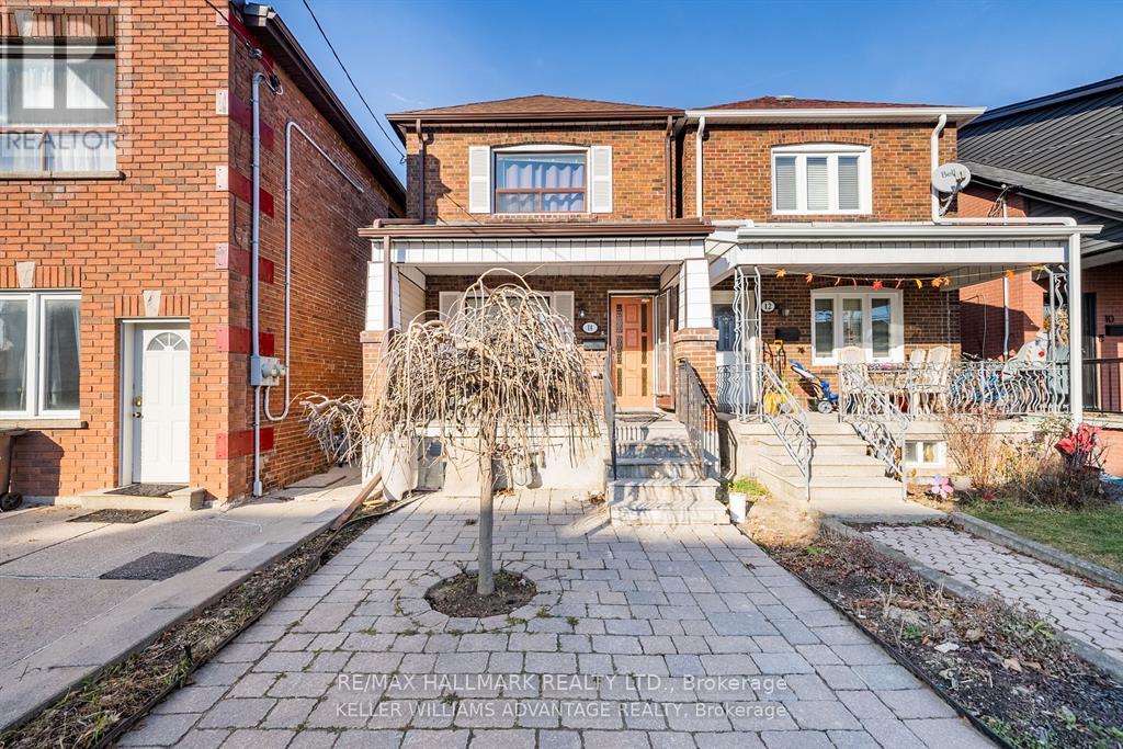 A brick house with a front yard and a tree in the front.