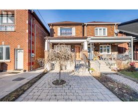 A brick house with a front yard and a tree in the front.
