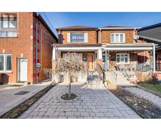 A brick house with a front yard and a tree in the front.