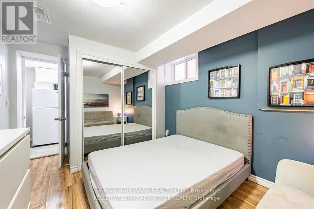 A bedroom with a bed, a chair, and pictures on the wall.
