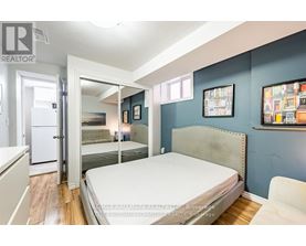 A bedroom with a bed, a chair, and pictures on the wall.
