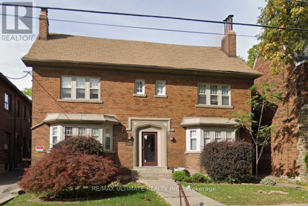 A brick house with a brown roof and a chimney.