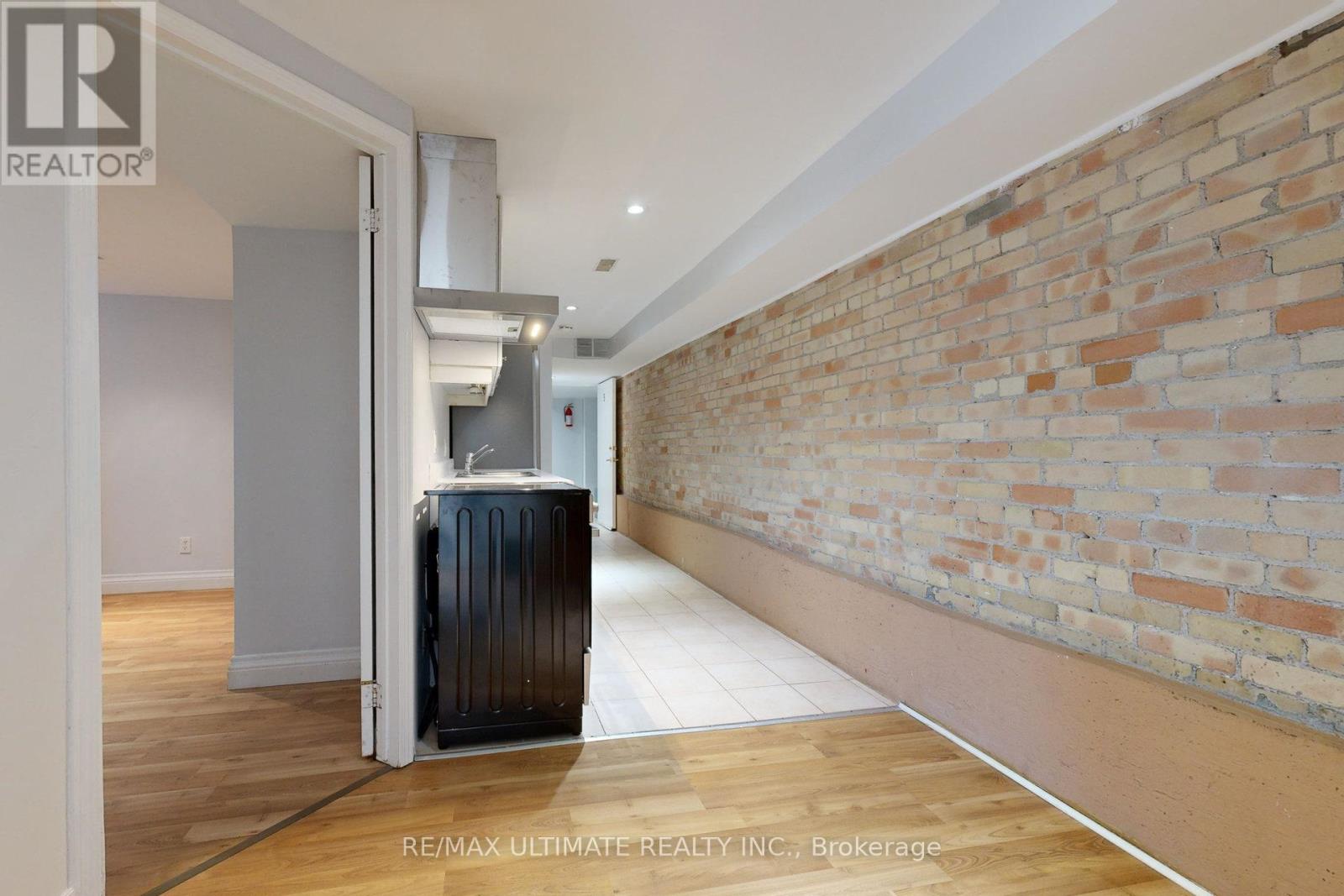 A room with a brick wall and a wooden floor.