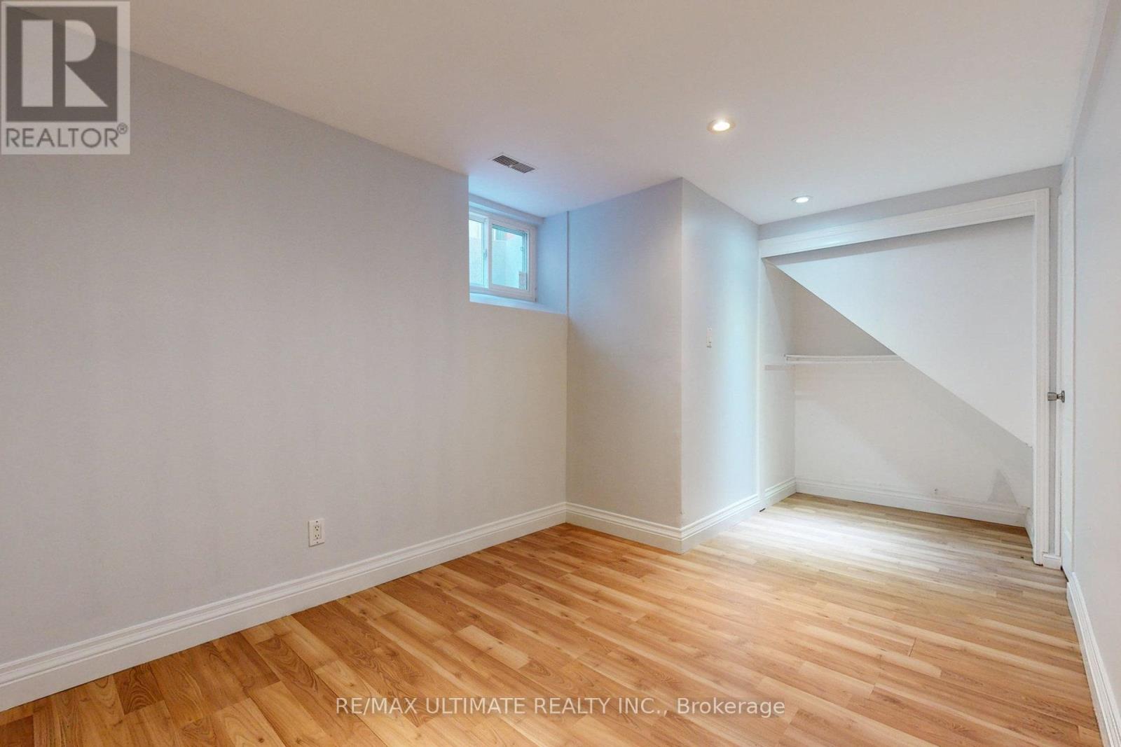 A room with wooden flooring and white walls.