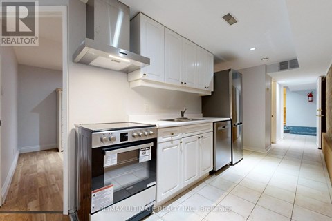 A modern kitchen with white cabinets and stainless steel appliances.