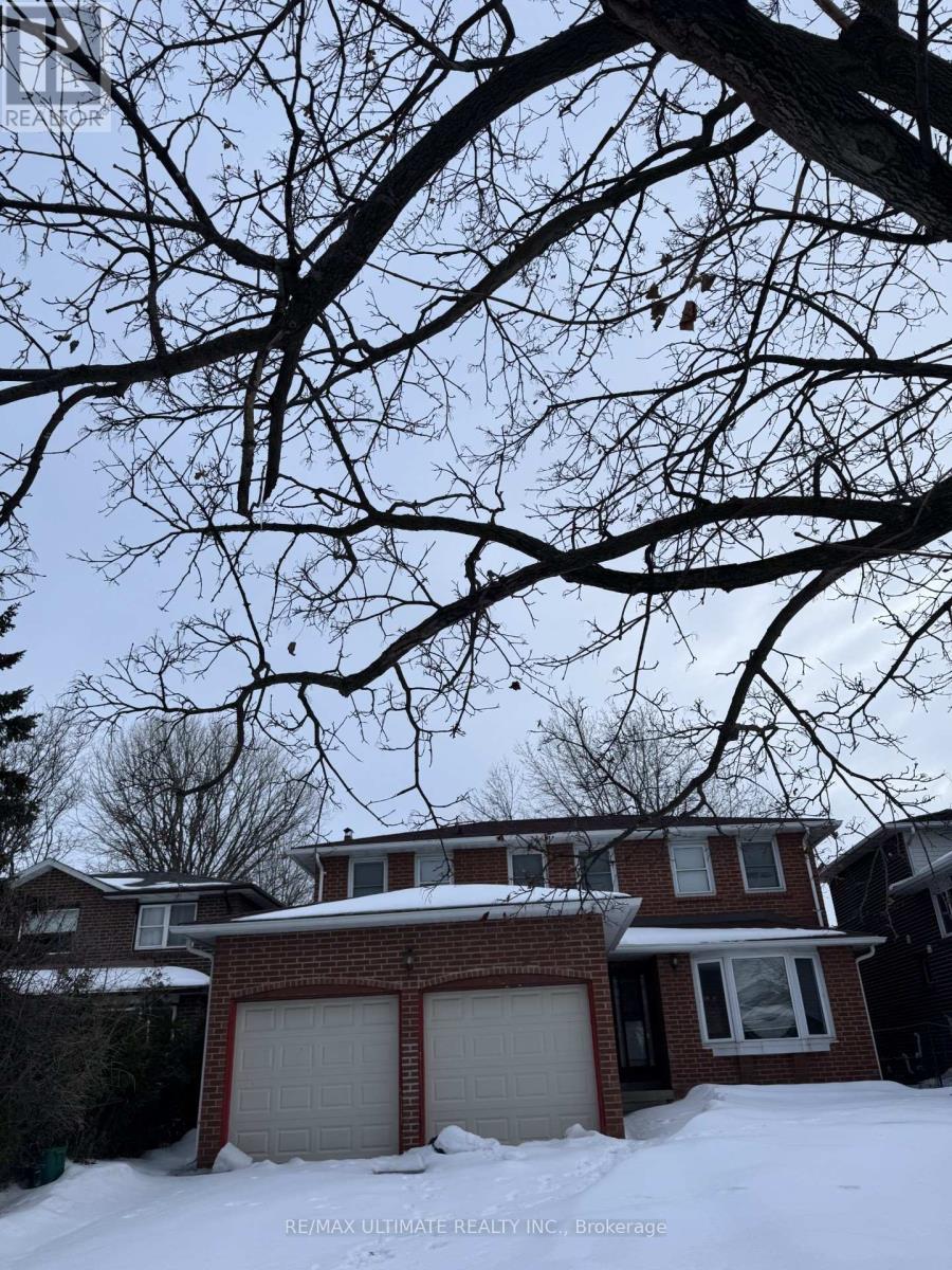 A house with a snow-covered ground and a tree branch in the foreground.