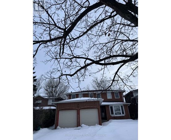 A house with a snow-covered ground and a tree branch in the foreground.