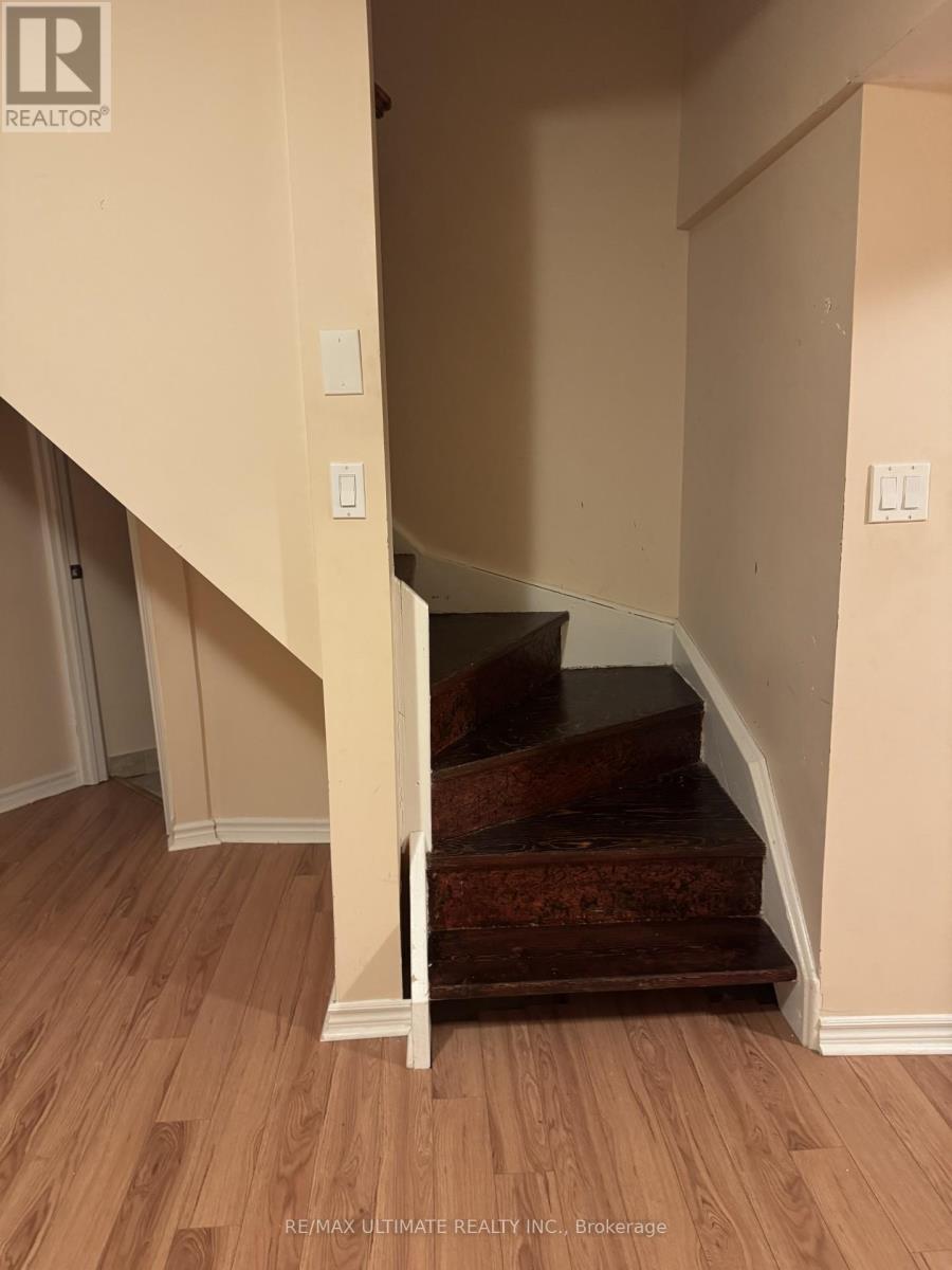 A staircase with a wooden handrail and steps leading up to a landing.
