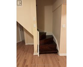 A staircase with a wooden handrail and steps leading up to a landing.