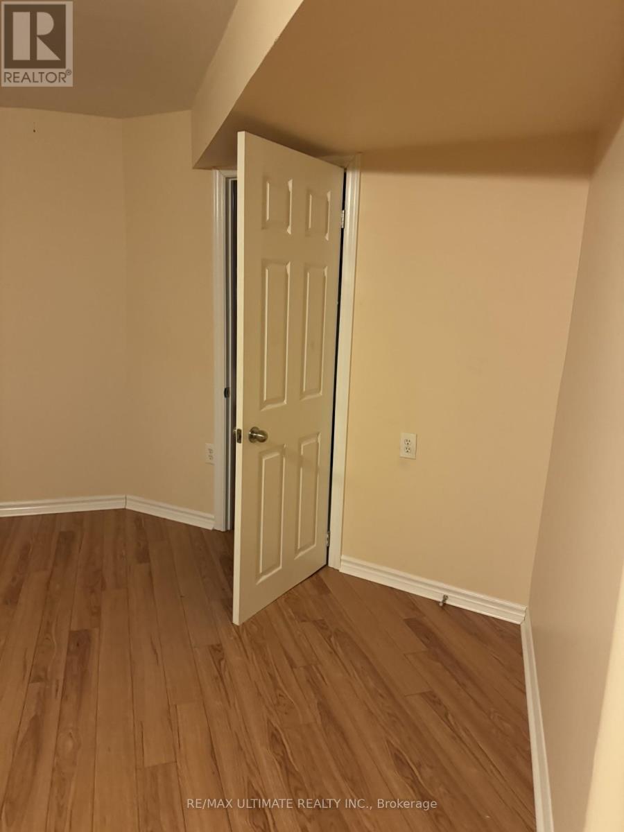 A white door is open in a room with wood flooring.