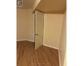 A white door is open in a room with wood flooring.