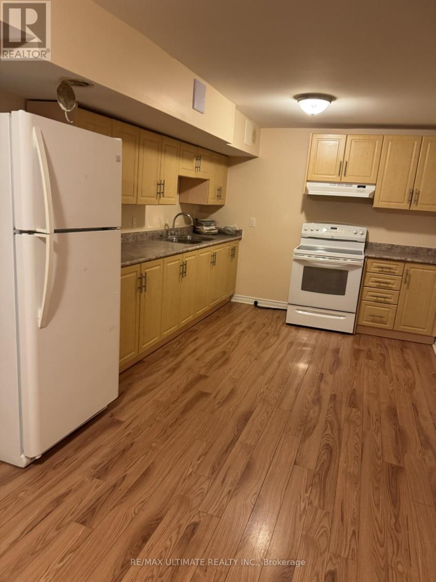 A kitchen with a white refrigerator and wooden cabinets.
