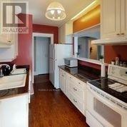 A kitchen with white cabinets and a black counter top.