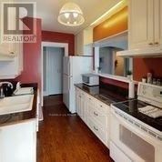 A kitchen with white cabinets and a black counter top.
