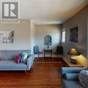 A living room with a grey couch and a wooden floor.