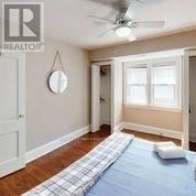 A bedroom with a bed and a fan on the ceiling.