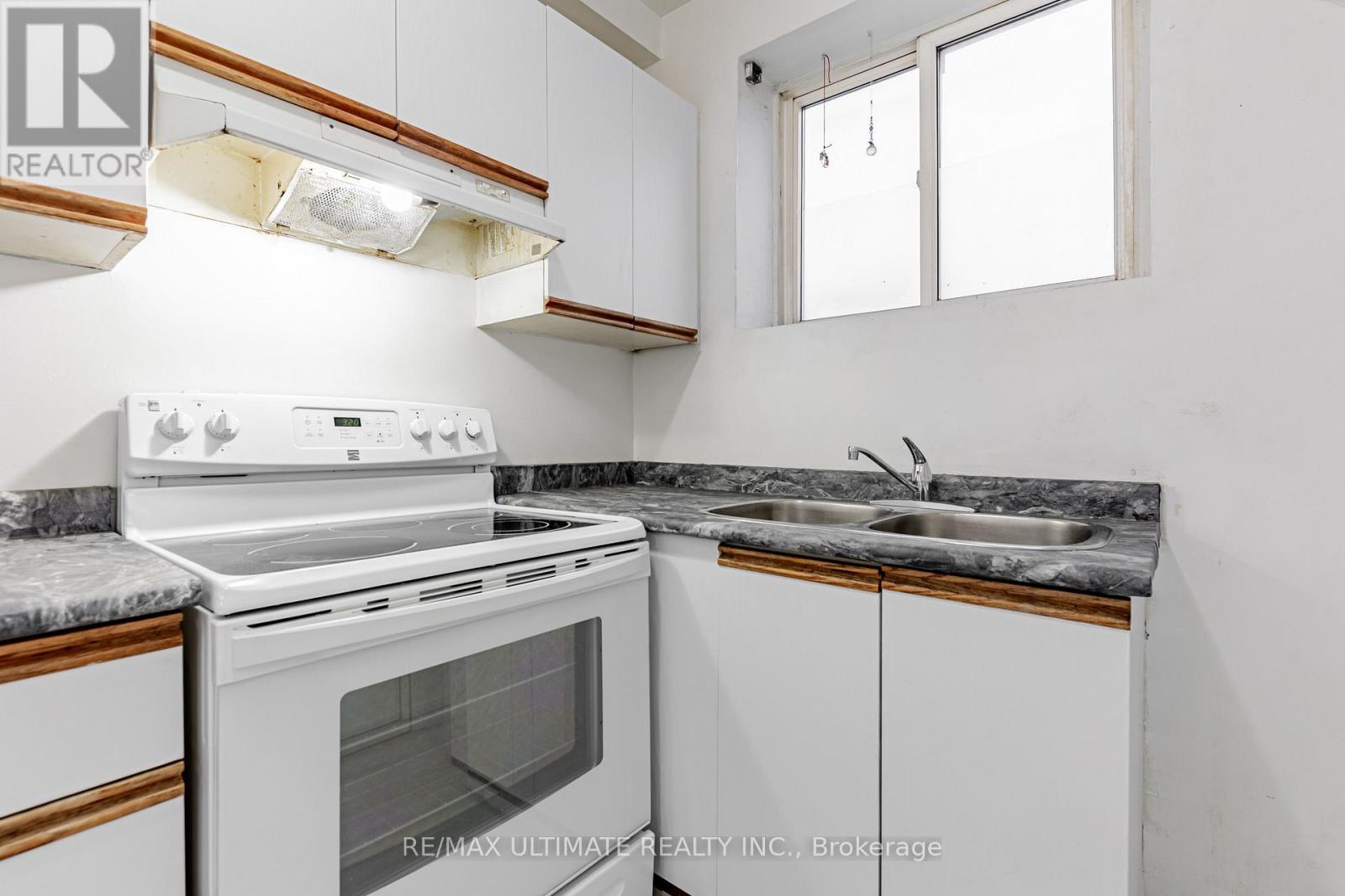 A white stove and sink in a kitchen.