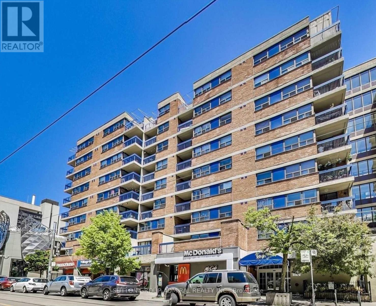 A tall apartment building with a McDonald's restaurant in front.
