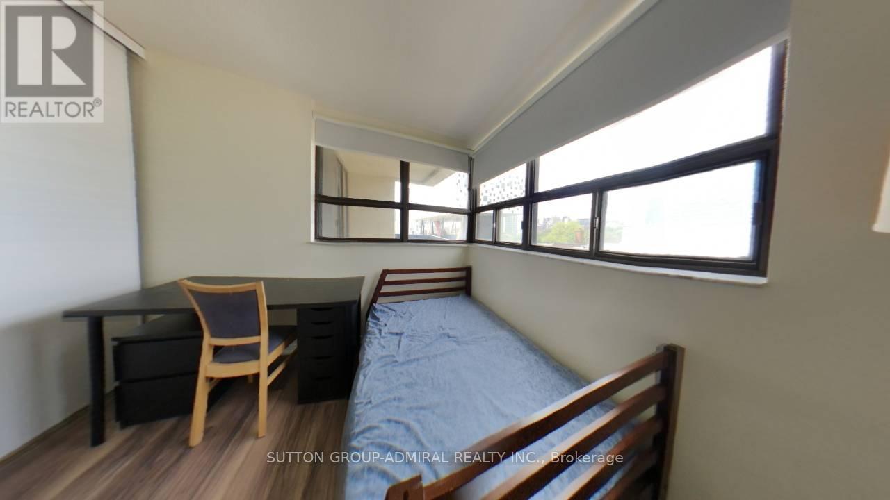A bedroom with a bed, desk, and chair.