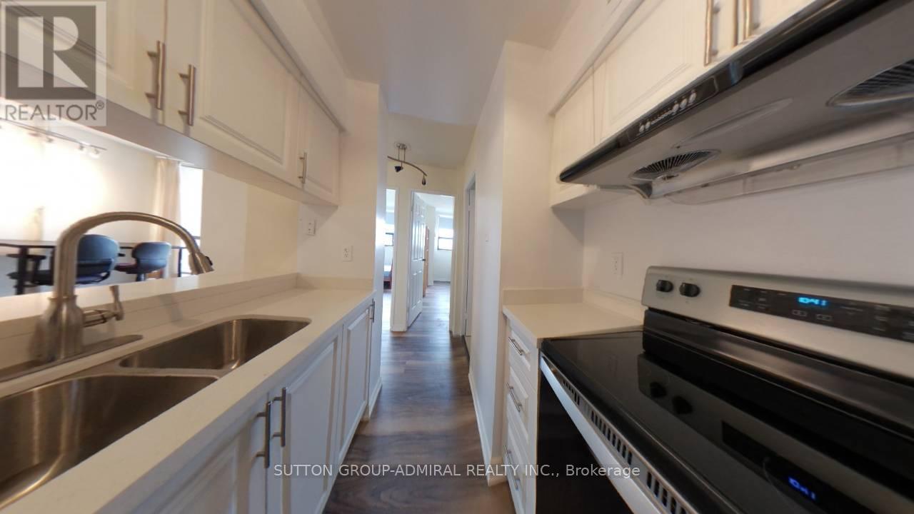 A modern kitchen with white cabinets and stainless steel appliances.