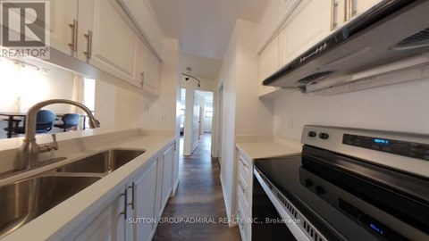 A modern kitchen with white cabinets and stainless steel appliances.