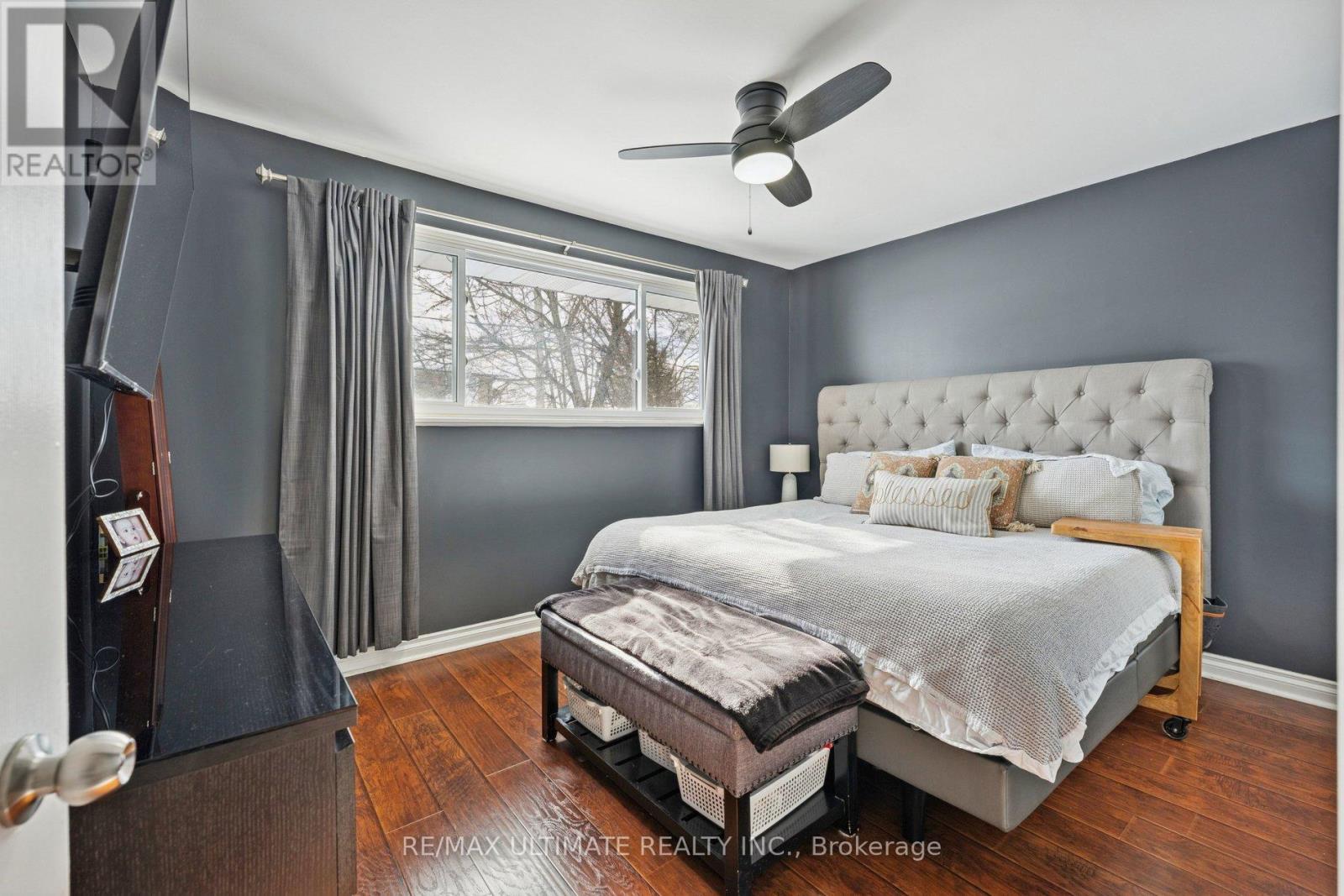 A bedroom with a large bed and a ceiling fan.