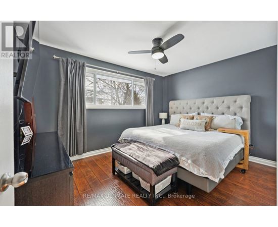 A bedroom with a large bed and a ceiling fan.