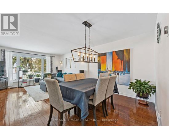 A dining room with a table set for four and a large painting on the wall.