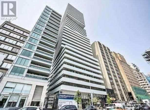 A tall building with a glass facade stands in front of a smaller building with a sign that reads "REALTOR".