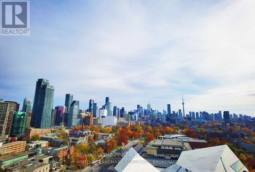A cityscape with a mix of modern and older buildings, with trees showing autumn colors.