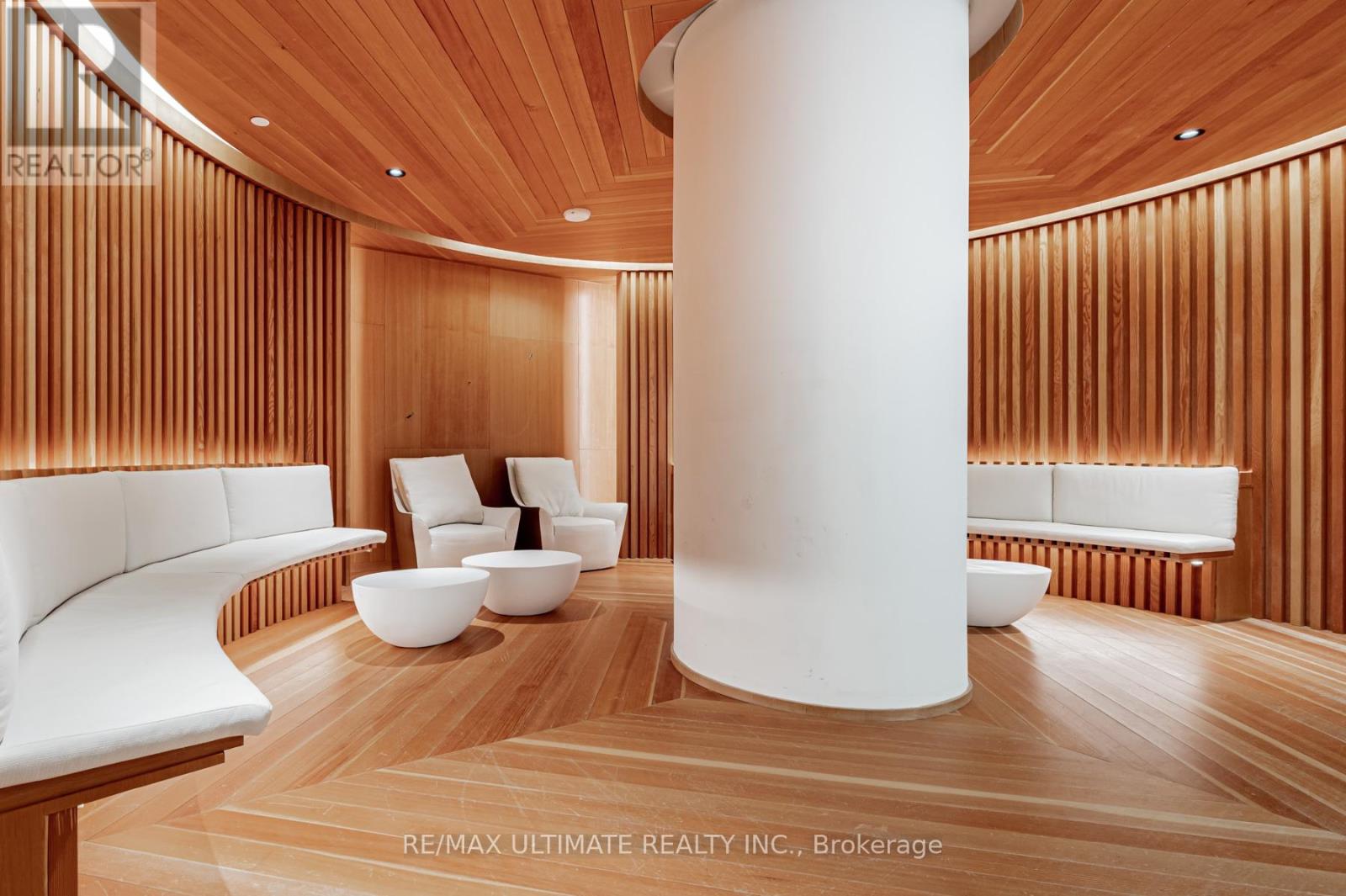 A modern living room with a white column and wooden floors.