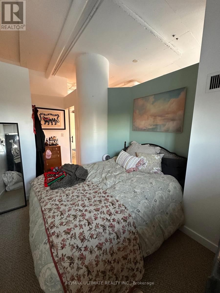 A bedroom with a large bed and a painting on the wall.