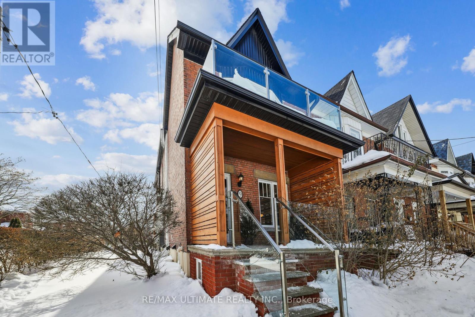 A house with a balcony is surrounded by snow.