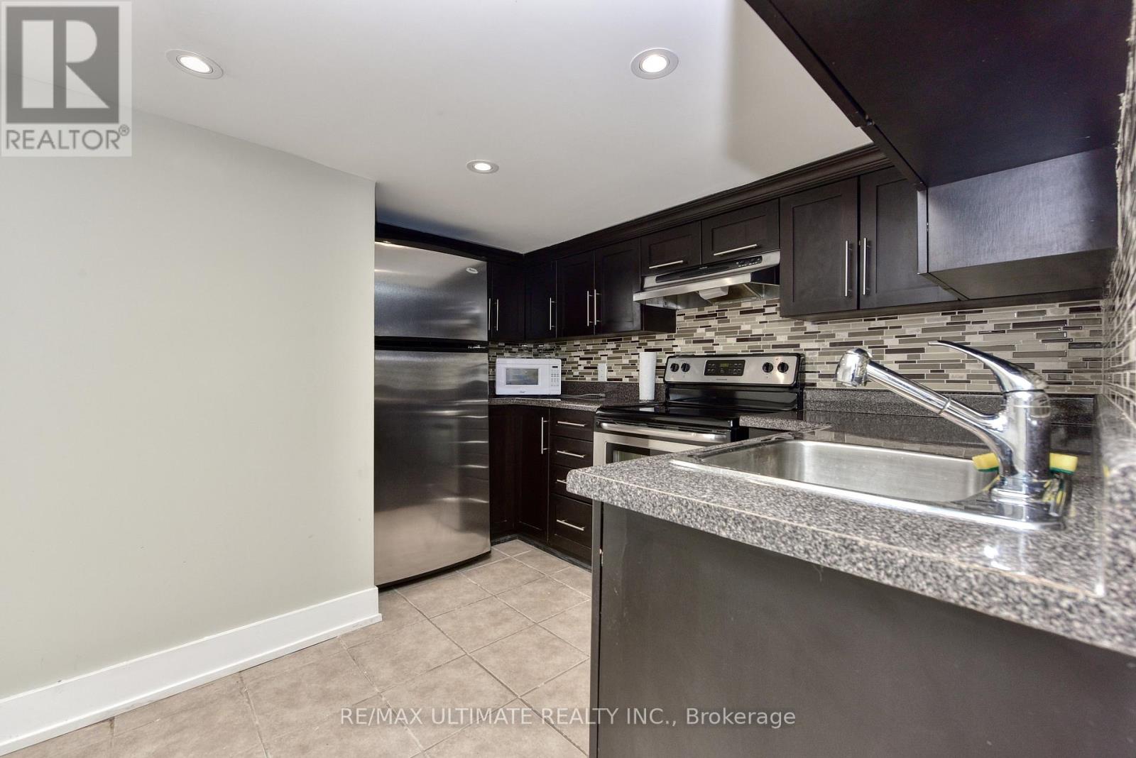 A modern kitchen with stainless steel appliances and a granite countertop.
