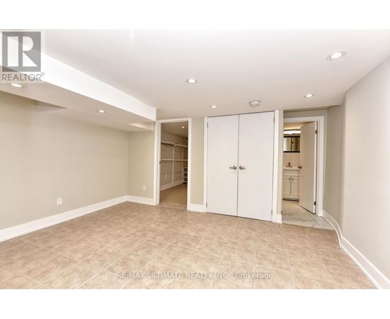 A spacious room with beige walls and carpeted floor, featuring a white door and a white cabinet.