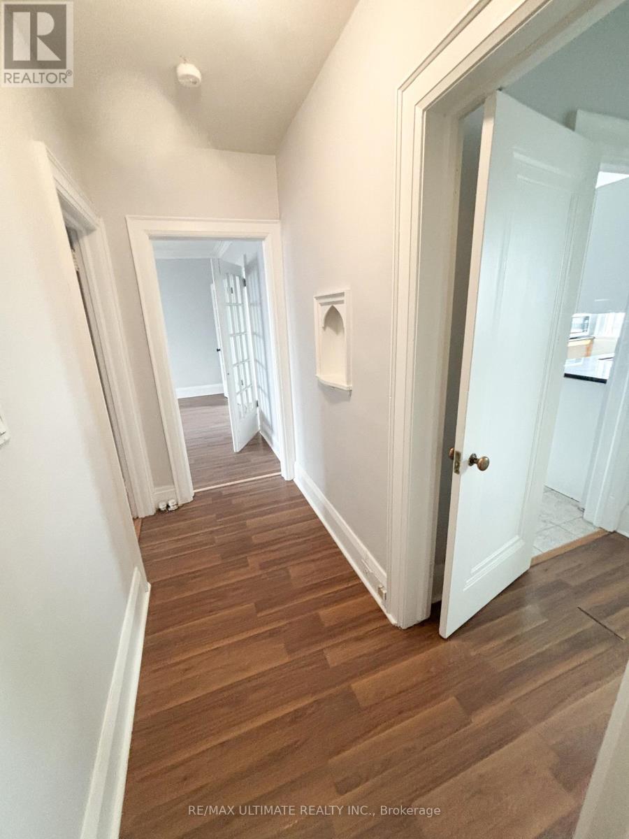 A hallway with wood floors and white walls.