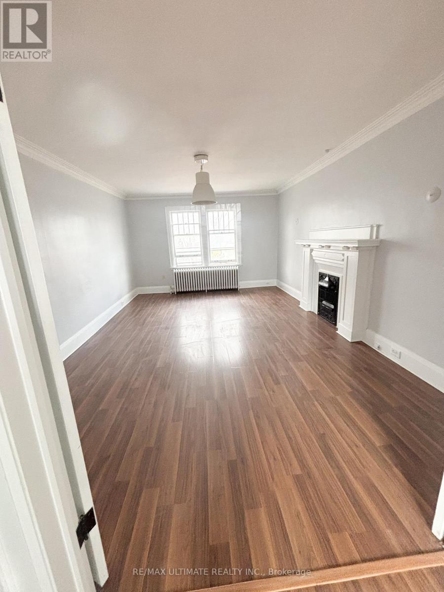 A room with wooden flooring and a fireplace.