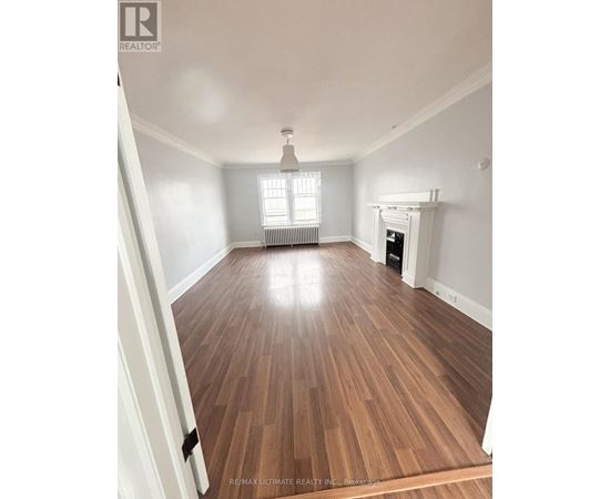 A room with wooden flooring and a fireplace.