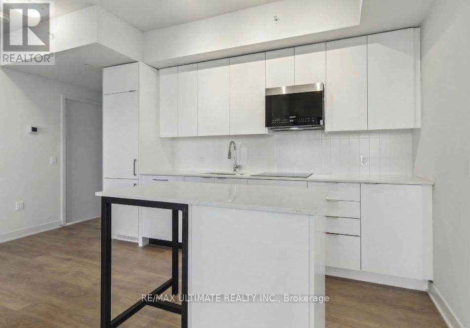 A white kitchen with a black stool.