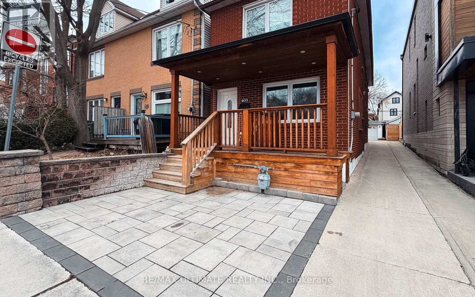 A house with a wooden deck and a stone wall.
