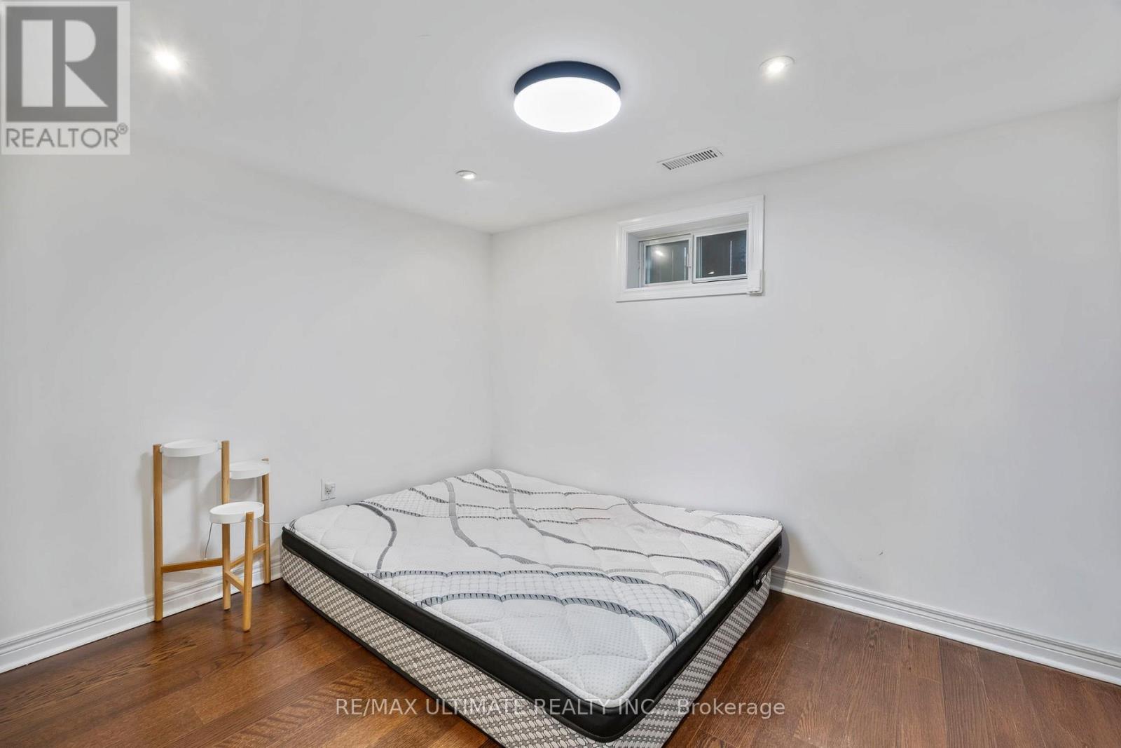 A bedroom with a bed, a chair, and a window.