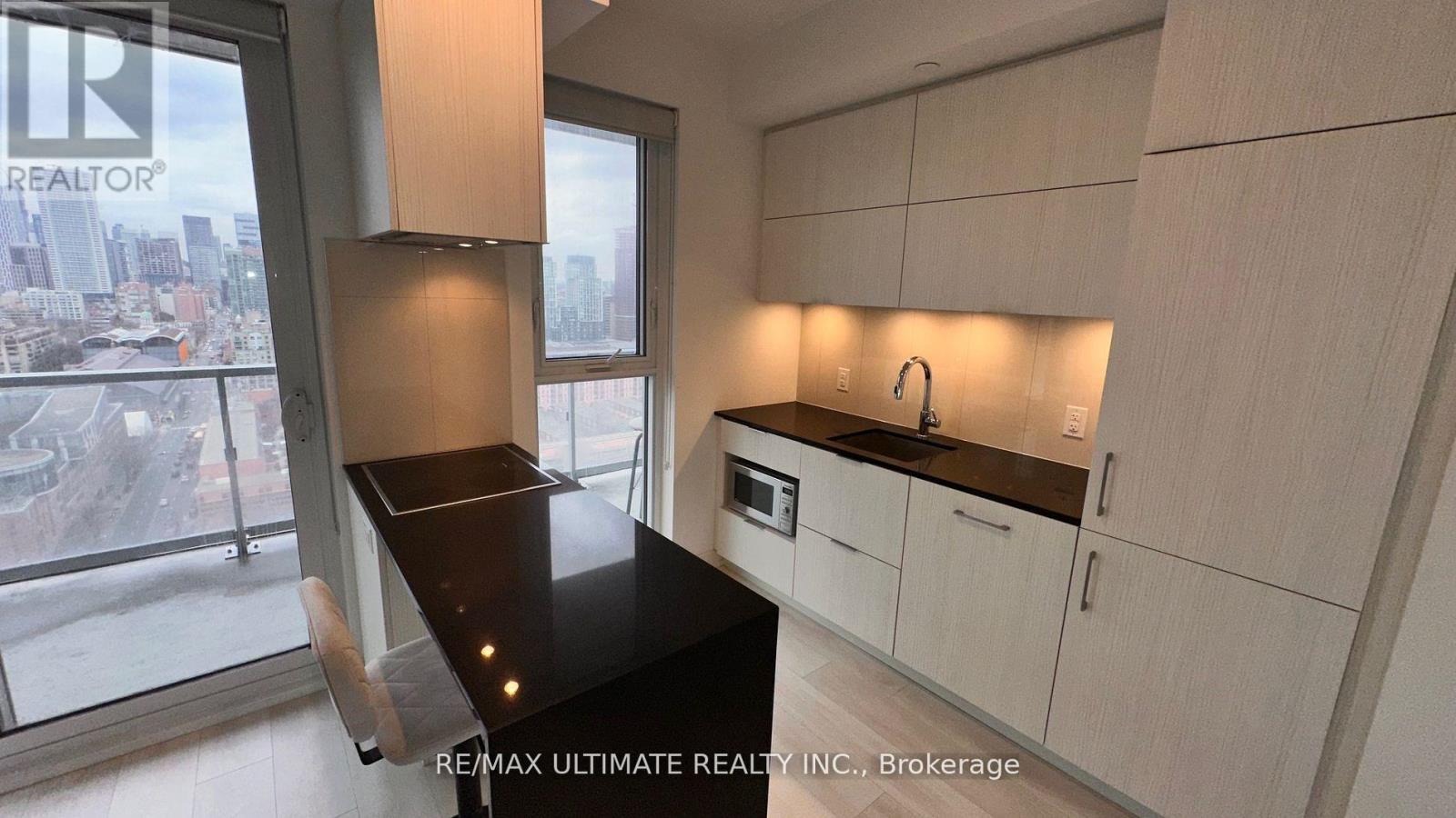 A modern kitchen with white cabinets and a black countertop.