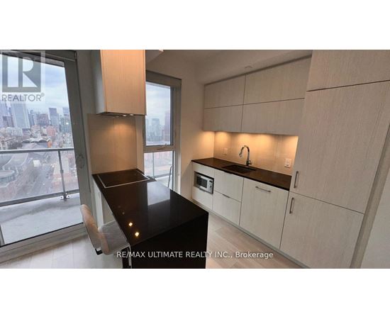 A modern kitchen with white cabinets and a black countertop.