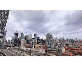 A cityscape with a cloudy sky and a highway in the foreground.