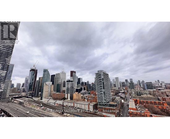 A cityscape with a cloudy sky and a highway in the foreground.