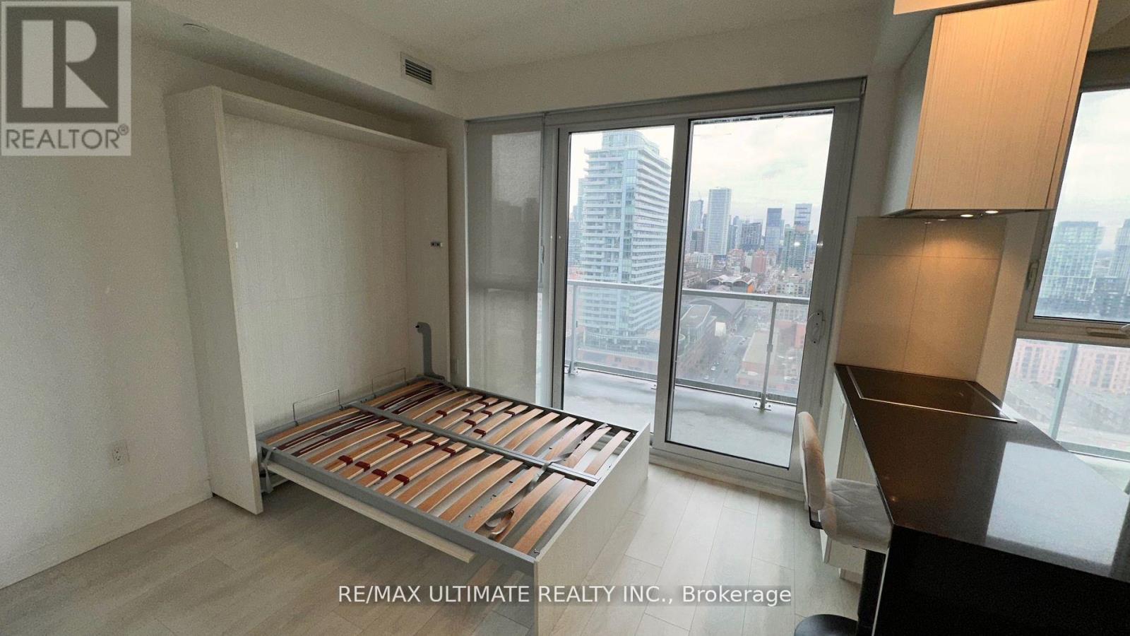 A bedroom with a large bed and a view of the city.
