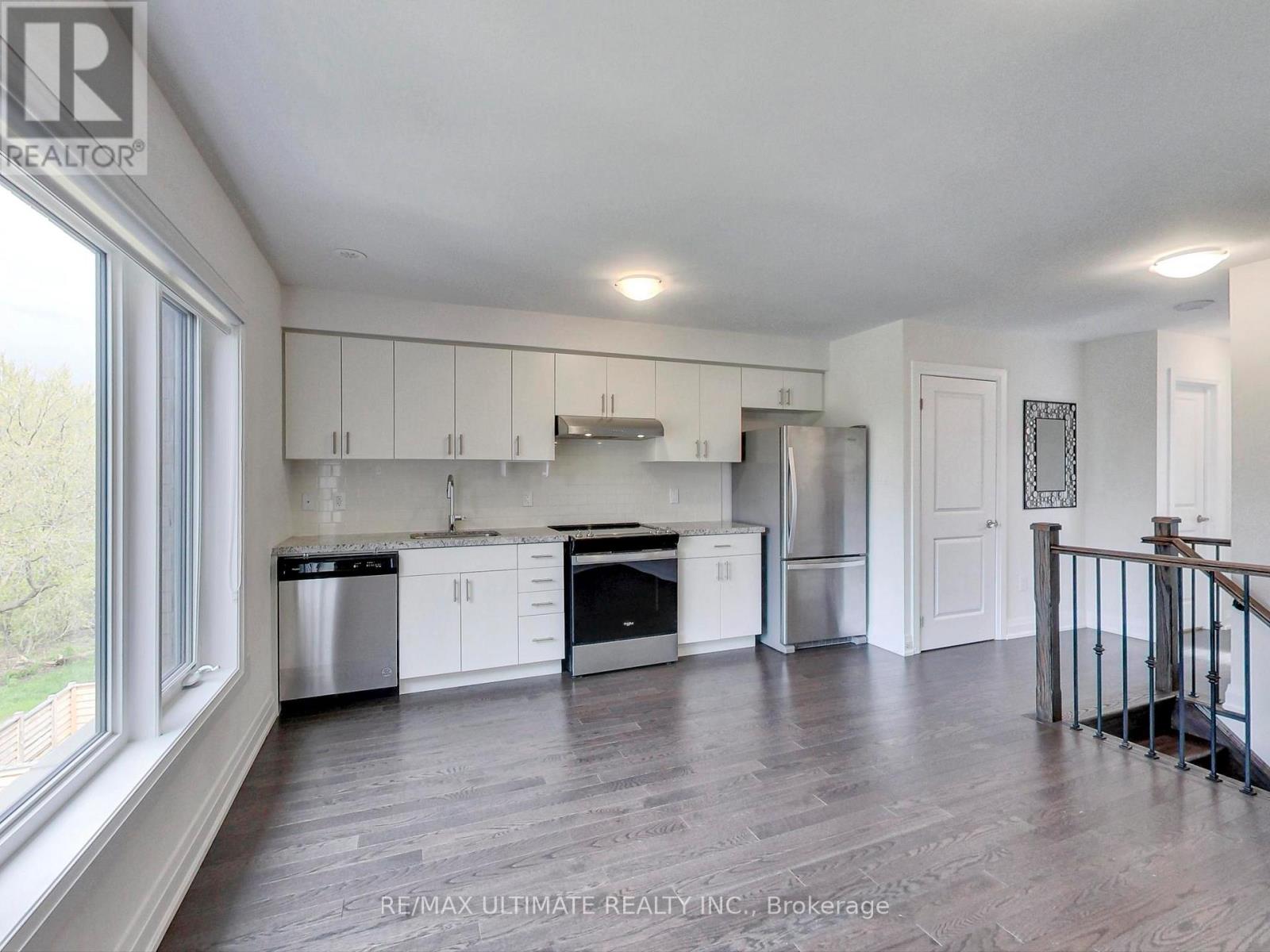 A spacious kitchen with white cabinets and stainless steel appliances.