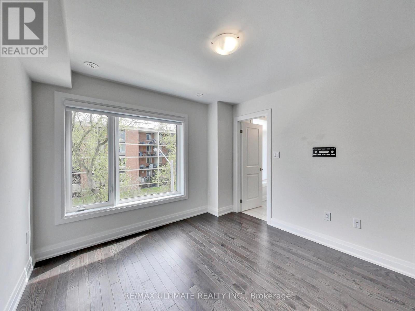 A room with a window showing a view of a building outside.